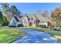 Beautiful two-story home with a circular driveway and well-manicured lawn at 3871 River Mansion Dr, Peachtree Corners, GA 30096