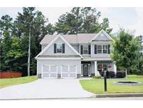 Charming two-story home with a well-manicured lawn and a spacious driveway leading to a two-car garage at 200 Stone Lake Dr, Dallas, GA 30157