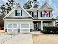 Charming two-story home boasts a well-maintained lawn, inviting curb appeal, and a convenient two-car garage at 200 Stone Lake Dr, Dallas, GA 30157