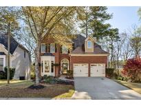 Charming red brick home featuring a two-car garage and well-maintained landscaping at 4212 Lazy Creek Dr, Marietta, GA 30066