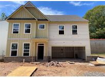 New two story home featuring large windows and an open garage in a construction phase at 4300 Easter Lily Ave Lot 11, Buford, GA 30519