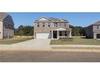 Charming two-story brick home with a two-car garage and a well-manicured lawn at 136 Dalston Cv, Stockbridge, GA 30281