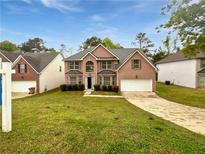 Charming two-story brick home featuring a well-manicured lawn and attached two-car garage at 1882 Byrom Pkwy, Jonesboro, GA 30236