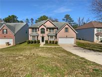 Charming brick home with a well-manicured lawn, attached garage, and inviting curb appeal on a sunny day at 1882 Byrom Pkwy, Jonesboro, GA 30236