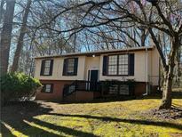 Split-level home featuring a brick foundation, front porch, and an inviting facade in a wooded neighborhood at 6625 Paula Ct, Lithonia, GA 30038
