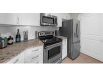Modern kitchen featuring stainless steel appliances, white cabinetry and marble countertops at 325 E Paces Ferry Ne Rd # 504, Atlanta, GA 30305