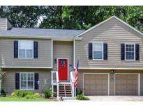 Charming home with a red door, black shutters, and an American flag at 3570 Mill Creek Drive Sw Dr, Smyrna, GA 30082