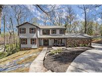 Charming two-story home with stone accents, symmetrical windows, and beautiful landscaping at 7055 Hunters Branch Dr, Atlanta, GA 30328