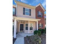 Charming townhouse with a covered front porch, beige siding, and brick accents offers a welcoming curb appeal at 2555 Flat Shoals Rd # 3103, Atlanta, GA 30349