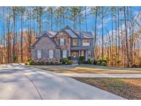 Stately two-story home with brick and stone facade and manicured landscaping at 205 Bergen Dr, Fayetteville, GA 30215