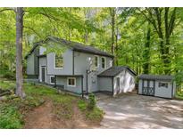 Two-story home with gray siding and a well-maintained yard surrounded by mature trees at 1291 Marcelle Heights Pl, Norcross, GA 30093