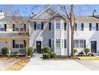 Two-story townhouse features a concrete driveway and trimmed bushes in front of the home at 217 Enterprise Path, Hiram, GA 30141