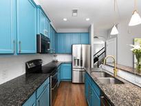 Bright kitchen features granite countertops, stainless steel appliances, and stylish blue cabinets at 2296 Whiteoak Se Dr, Smyrna, GA 30080