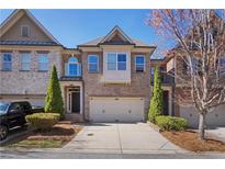 Charming brick townhome featuring an attached two-car garage and beautifully landscaped front yard at 7630 Glisten Ave # 304, Atlanta, GA 30328