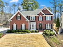 Stately brick two-story home with black shutters, well-manicured landscaping, and a welcoming entrance at 2046 Woodside Park Dr, Woodstock, GA 30188