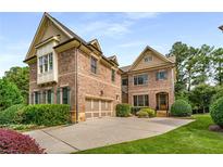 Charming two-story brick home featuring a well-manicured lawn, attached garage, and professionally landscaped yard at 2750 Vinings Orchard Se Cir, Atlanta, GA 30339