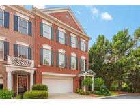 Charming brick townhome with two-car garage, manicured landscaping, and beautiful architectural details at 2314 English Ivy Se Ct, Atlanta, GA 30339
