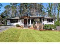 Charming one-story home featuring a welcoming front porch and well-manicured lawn at 3480 Dunn Se St, Smyrna, GA 30080
