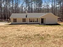 Charming single-story home with a neutral exterior and a well-maintained yard surrounded by a lush tree line at 70 Wall St, Hampton, GA 30228