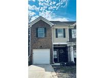 Charming two-story townhome with a one-car garage and brick facade at 1545 Iris Walk, Jonesboro, GA 30238