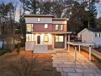 Modern two-story home featuring clean lines, a carport, and a stylish stone pathway to the front door at 1045 Shepherds Ne Ln, Atlanta, GA 30324