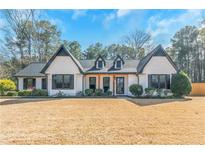 Charming home featuring a well-manicured lawn, contrasting black and white trim and new front porch at 165 Sugarland Trl, Fayetteville, GA 30214