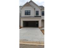 Two-story townhome features white painted brick and board and batten siding, plus a two-car garage at 1063 Crest Mill Dr, Marietta, GA 30008