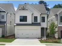 Charming two-story home features a white brick and siding, black trim windows, and a two-car garage at 1063 Crest Mill Dr, Marietta, GA 30008