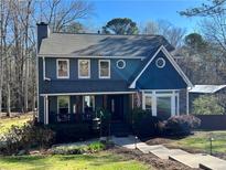 Charming two-story home with a covered front porch, lush landscaping, and a well-maintained lawn at 92 Indian Lake Ct, Hiram, GA 30141