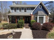 Charming two-story home featuring stone accents, a covered porch, and manicured landscaping at 92 Indian Lake Ct, Hiram, GA 30141