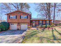 Charming split-level home featuring a well-maintained yard, two-car garage and wood facade at 2685 Whippoorwill Cir, Duluth, GA 30097