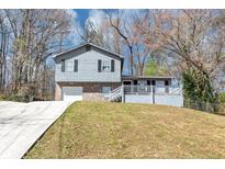 Charming home featuring a stone accent front, light gray paint, and a cozy front porch at 3671 Satellite Blvd, Ellenwood, GA 30294