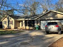 Cozy one-story home with a well-maintained lawn, attached garage, and a charming stone facade detail at 3511 Flint Ave, Ellenwood, GA 30294