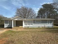 Charming single-story home featuring gray siding, a covered porch, and well-maintained landscaping at 2041 Olive Springs Se Rd, Marietta, GA 30060