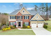 Inviting brick two-story home with a manicured lawn and a two-car garage, perfect for suburban living at 5009 Preservation Pointe Nw, Kennesaw, GA 30152