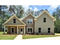 Charming two-story home with brick and siding, complemented by a well-manicured lawn and lush greenery at 121 Honey Creek Rd, Conyers, GA 30094