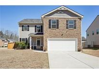 Charming two-story home featuring a brick facade, inviting entrance, and well-maintained lawn on a sunny day at 201 Cranapple Ln, Mcdonough, GA 30253