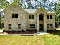 Inviting two-story brick home with a manicured lawn and mature trees, offering a classic suburban appeal at 123 Honey Creek Rd, Conyers, GA 30094