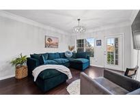 Cozy living room featuring a plush blue sectional sofa and modern chandelier lighting at 2700 Pine Tree Ne Rd # 1211, Atlanta, GA 30324