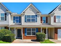 Traditional two-story townhouse with brick accents, blue shutters, and a well-maintained front yard at 5338 Creekview Ln, Morrow, GA 30260