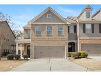 Charming two-story townhome featuring a brick facade and an attached two-car garage at 2308 Oakton Se Pl, Smyrna, GA 30082