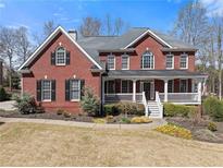 Charming two-story brick home with a welcoming front porch and well-maintained landscaping at 3070 Corsair Curv, Cumming, GA 30040