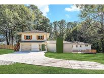 Charming two-story home with attached garage, lush lawn, and long driveway at 3085 Remington St, East Point, GA 30344