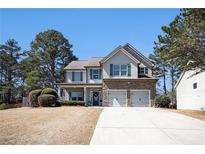 Charming two-story home featuring stone accents, a two-car garage, and a well-maintained front yard at 183 Gatlin Run, Dallas, GA 30157