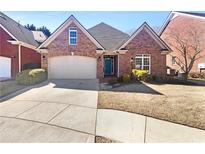 Charming brick home featuring a two-car garage and well-maintained landscaping at 1832 Glenwood Ln, Snellville, GA 30078