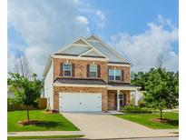 Charming two-story brick home featuring a two-car garage and a well-manicured front lawn at 3391 Meadow Grass Dr, Dacula, GA 30019