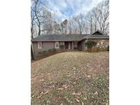 Charming one-story home featuring stone accents and a well-maintained front yard with mature trees at 610 Pine Grove Rd, Roswell, GA 30075