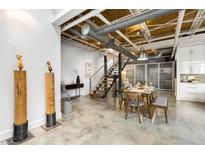 Open-concept living area featuring polished concrete floors, dining table, and staircase leading to the upper level at 834 Dekalb Ne Ave # D, Atlanta, GA 30307