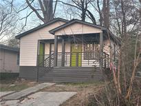 Charming bungalow featuring a welcoming porch, a newly painted facade, and a vibrant green door at 1170 Booker Sw Ave, Atlanta, GA 30310