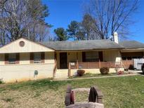 Charming single-story home with a quaint front porch and traditional design elements, set beneath a clear blue sky at 4574 Cedar Ridge Trl, Stone Mountain, GA 30083